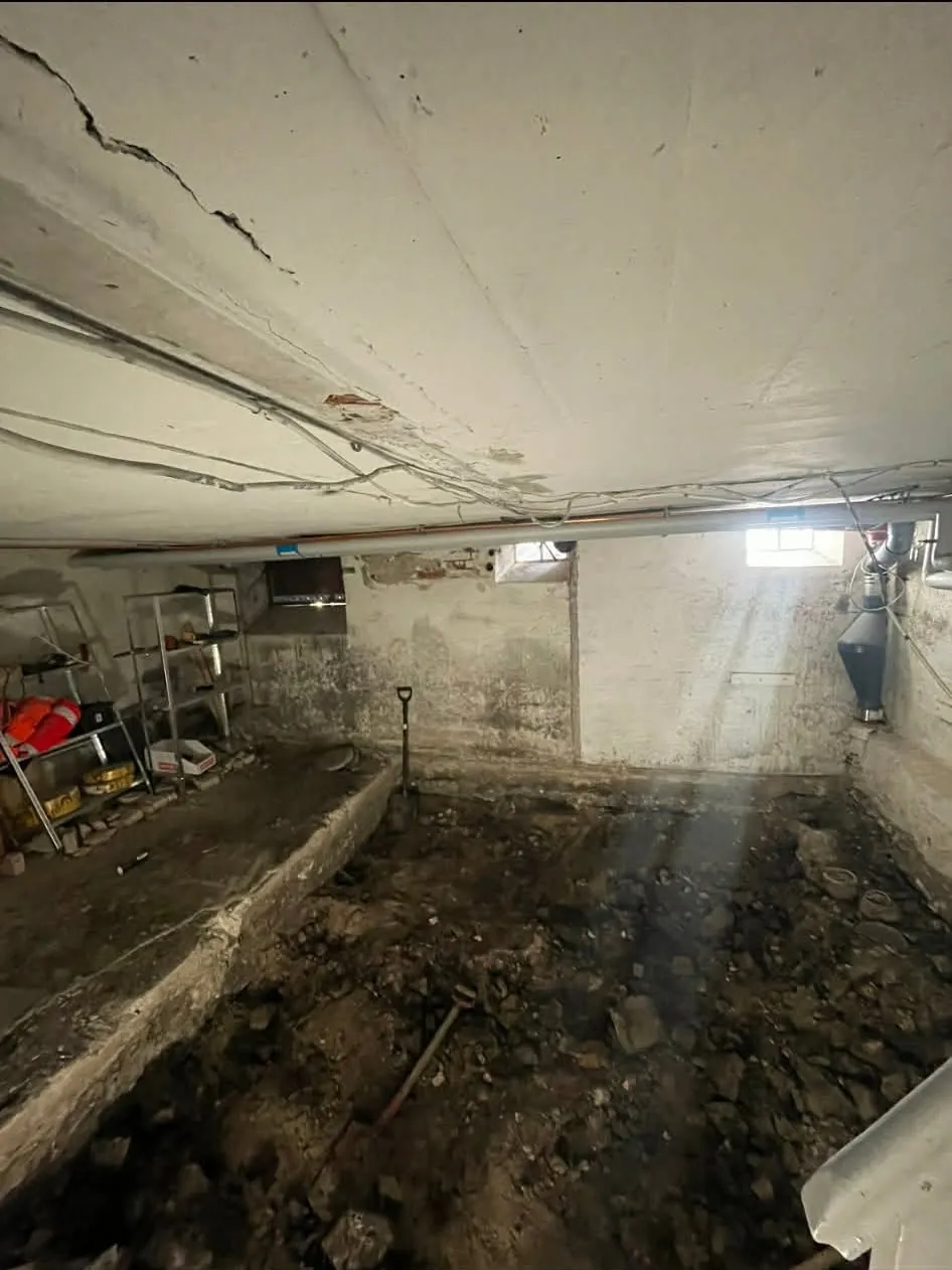 Rå kælder med udgravet gulv før totalrenovering